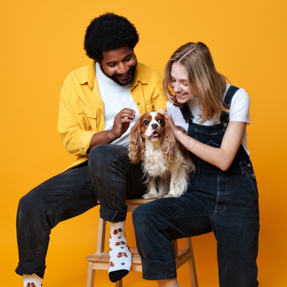 Girl and boy with custom pet socks cuddling with dog